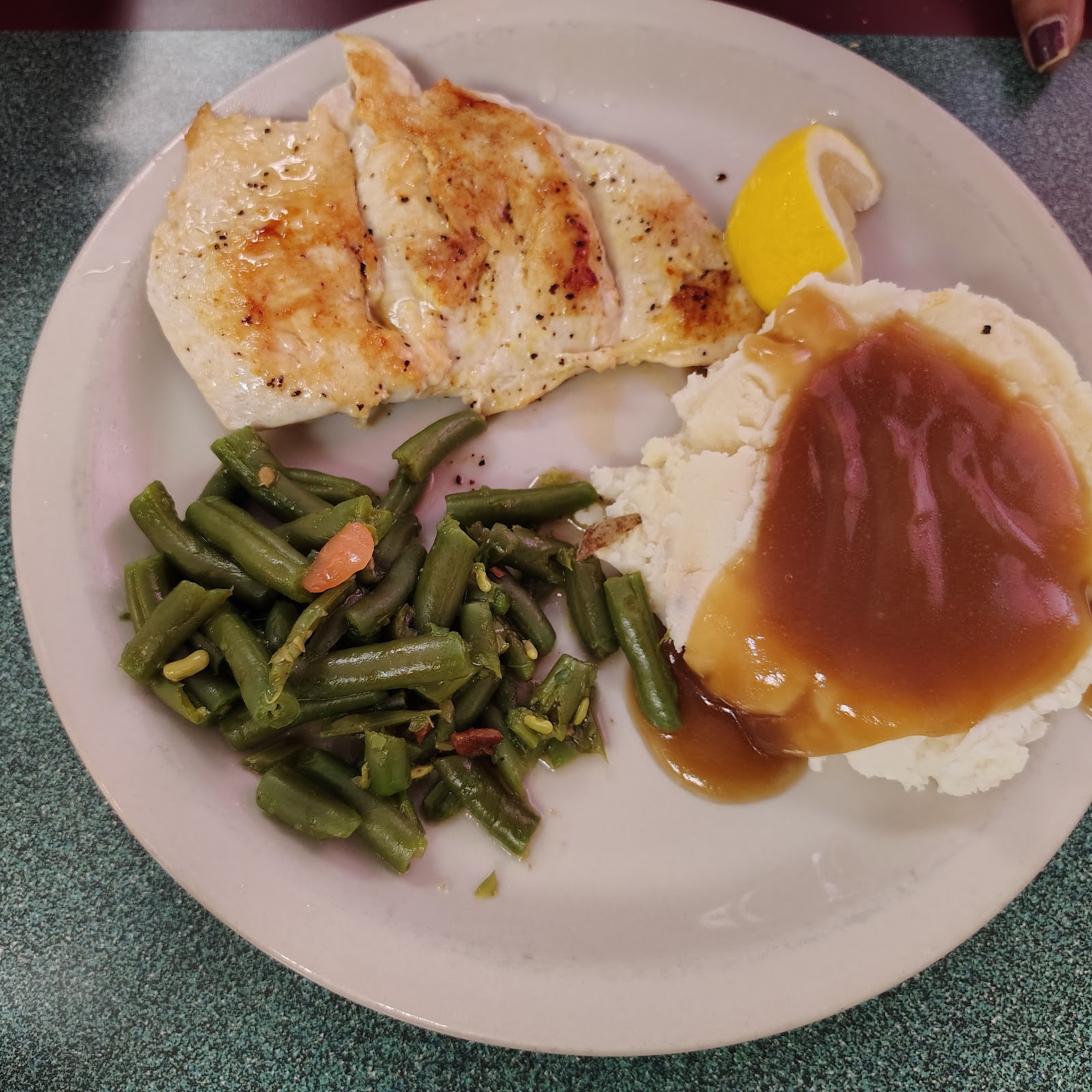 Grilled chicken plate with mashed potatoes, gravy and green beans